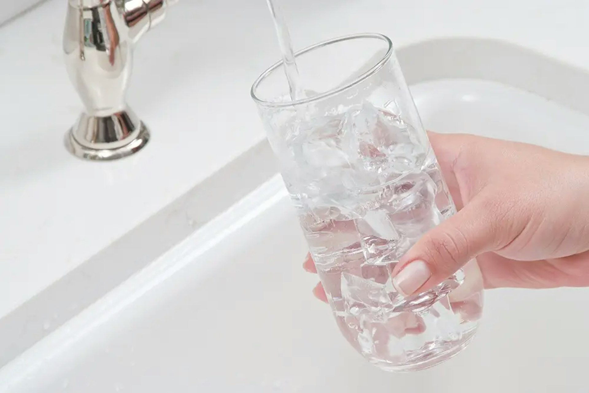 Woman-Filling-Glass-with-Ice-Water-Drinking-Water